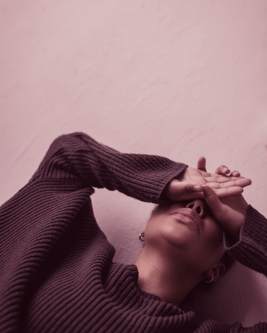 Une femme allongée, les mains posées sur les yeux
